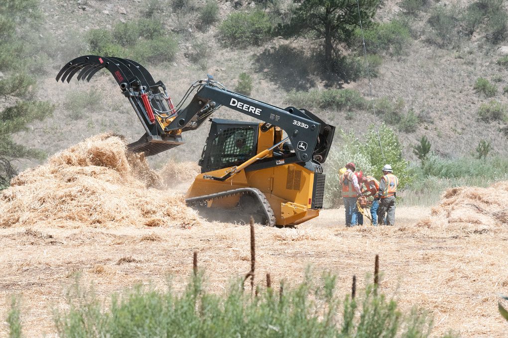 Hydraulic cylinders visible on a loader arm — the components we service